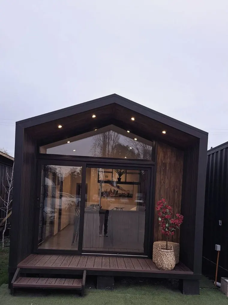 Casa modular negra con ventanales de termopanel