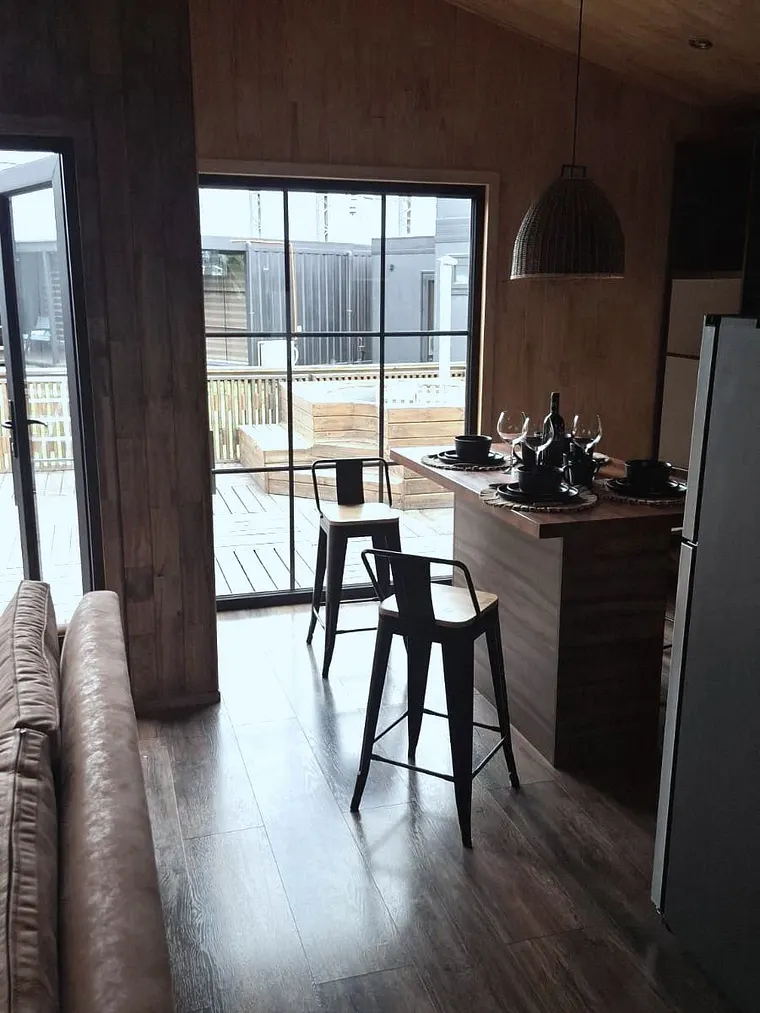 Interior de casa modular con ventanal fijo de termopanel y palillaje